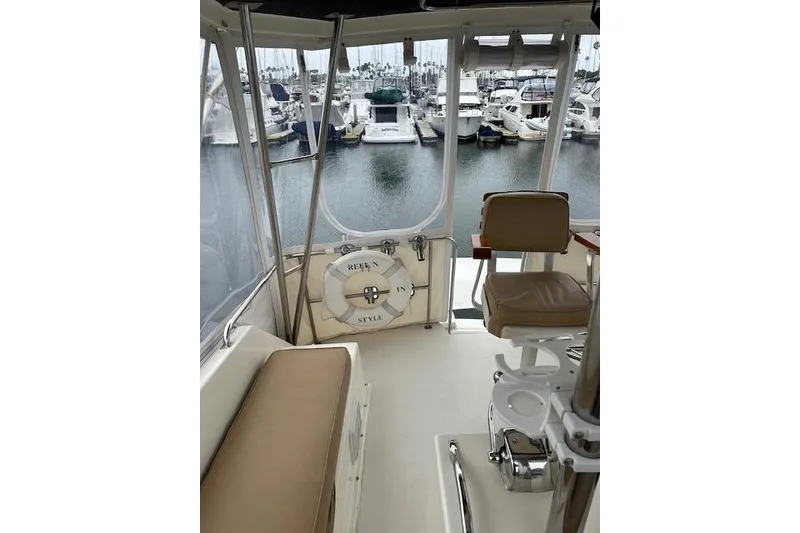 Slide: The Image of 1988 Ocean 44' Super Sport yacht interior with marina view, featuring seating and life preserver. - 10