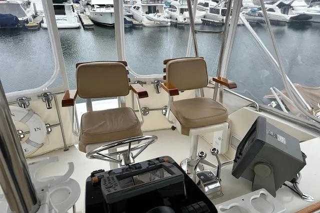 Slide: The Image of 1988 Ocean 44' Super Sport yacht helm with dual seats and marina view. - 13