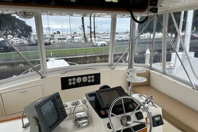Slide: The Image of 1988 Ocean 44' Super Sport yacht cockpit with navigation equipment and marina view. - 14