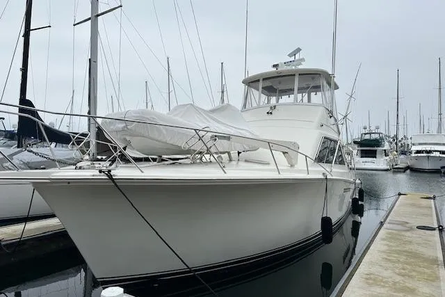 Slide: The Image of 1988 Ocean 44' Super Sport yacht docked at marina, overcast sky. - 2