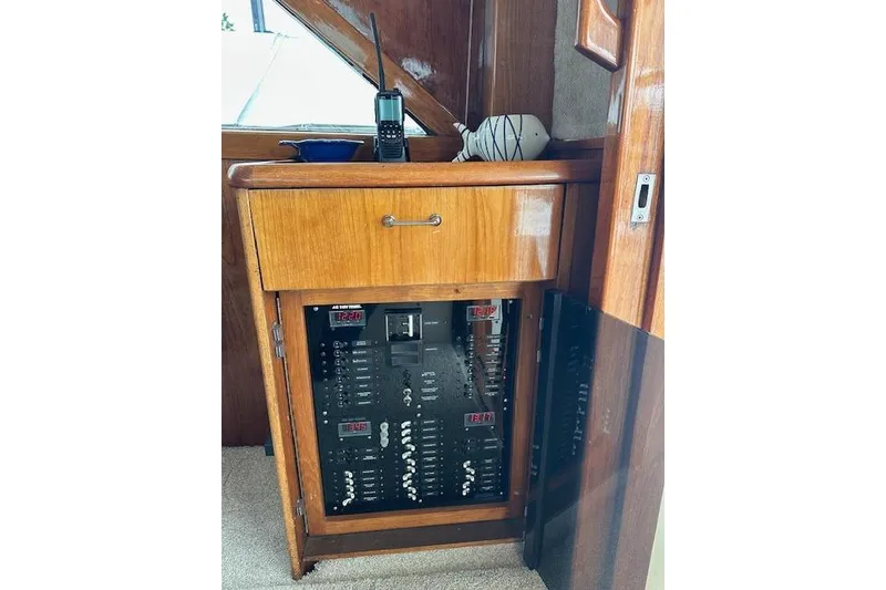 Slide: The Image of 1988 Ocean 44' Super Sport yacht electrical panel with wooden cabinet and radio. - 20