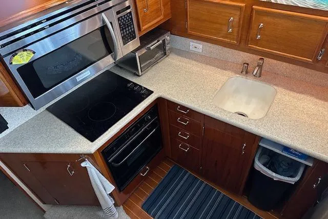 Slide: The Image of 1988 Ocean 44' Super Sport yacht kitchen with modern appliances and wooden cabinetry. - 31