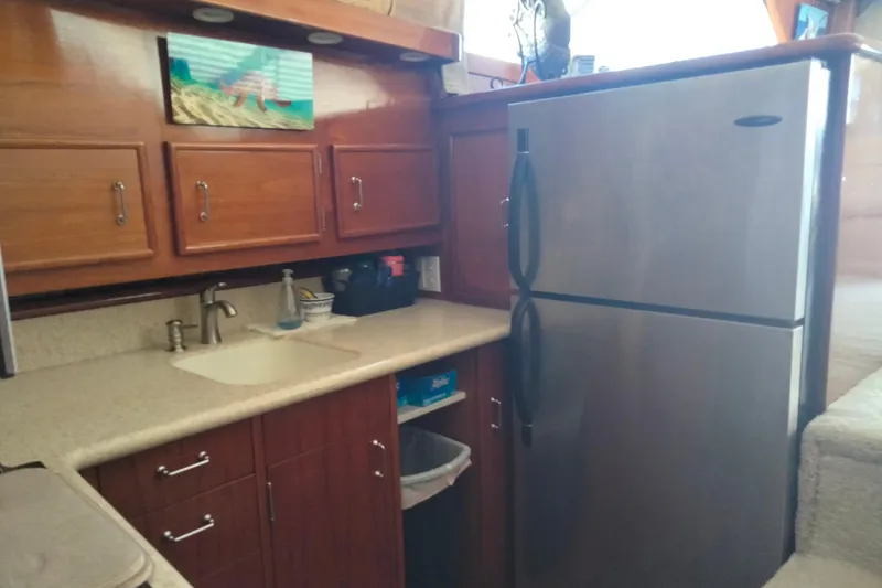 Slide: The Image of 1988 Ocean 44' Super Sport yacht kitchen with wooden cabinets and stainless steel refrigerator. - 32