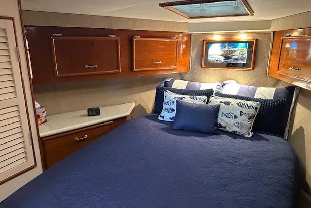 Slide: The Image of Cozy bedroom in 1988 Ocean 44' Super Sport yacht with blue bedding and wooden cabinets. - 37
