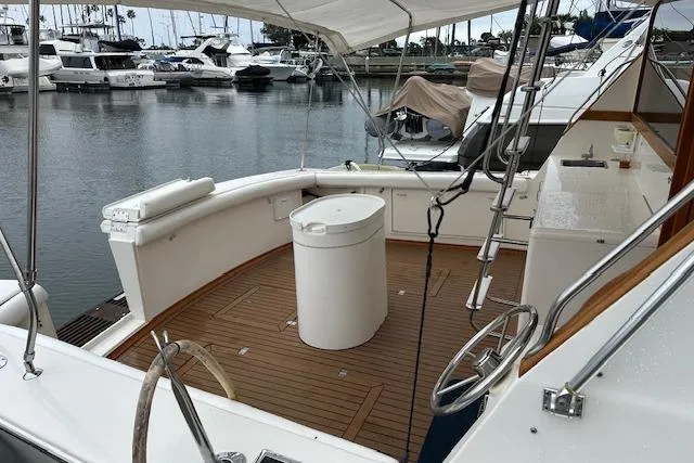 Slide: The Image of 1988 Ocean 44' Super Sport yacht docked at marina, featuring spacious deck and seating area. - 7