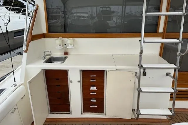Slide: The Image of 1988 Ocean 44' Super Sport yacht interior with sink, storage, and ladder. - 8