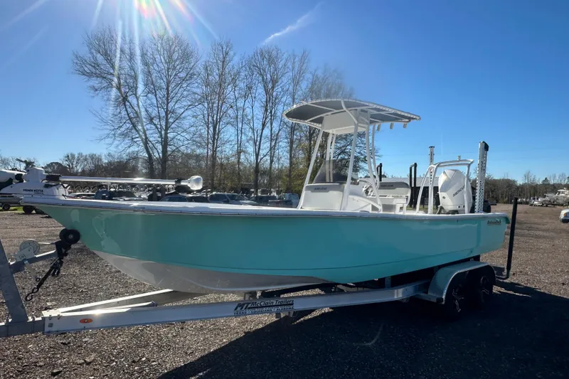 Slide: The Image of 2026 Action Craft 24 Bay boat on trailer, parked outdoors under clear blue sky. - 11
