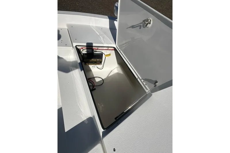 Slide: The Image of Open storage compartment on 2026 Action Craft 24 Bay boat, showing battery and wiring. - 25