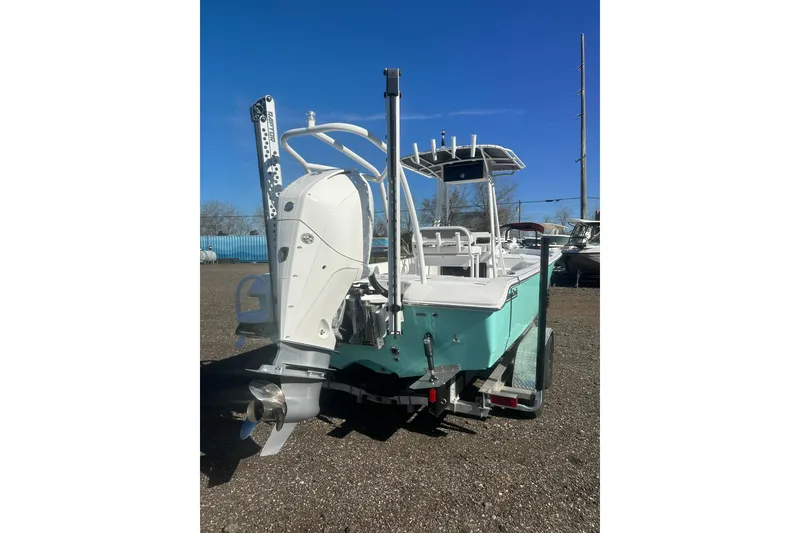 Slide: The Image of 2026 Action Craft 24 Bay boat with outboard motor on trailer, parked outdoors. - 4