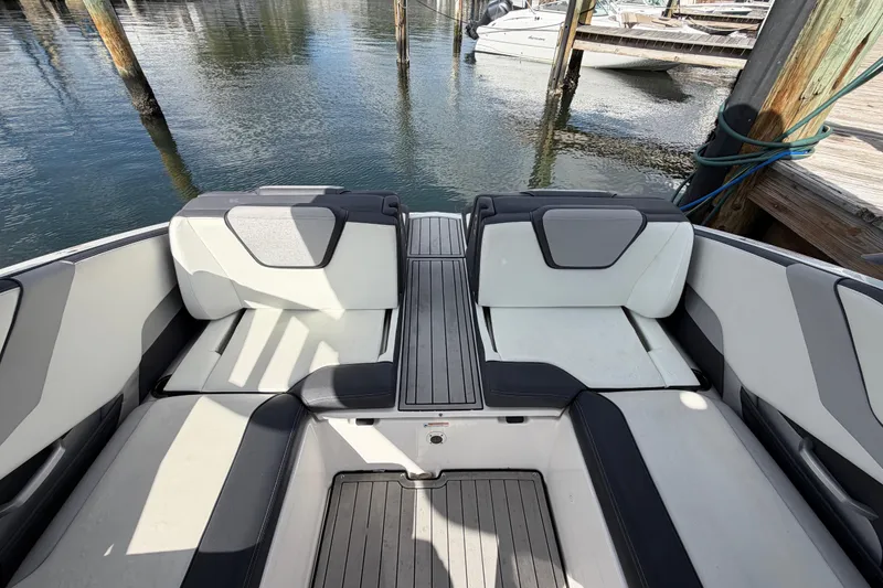 Slide: The Image of 2022 Yamaha Boats 252SD interior seating area at a dock. - 11