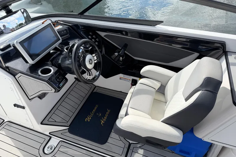 Slide: The Image of 2022 Yamaha Boats 252SD cockpit with steering wheel, touchscreen, and captain's chair. - 12
