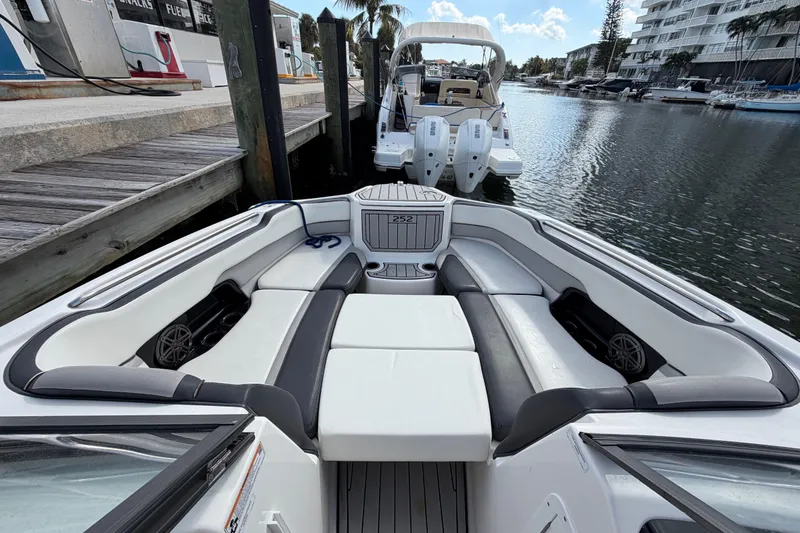 Slide: The Image of 2022 Yamaha Boats 252SD interior, docked in a marina with luxurious seating. - 25