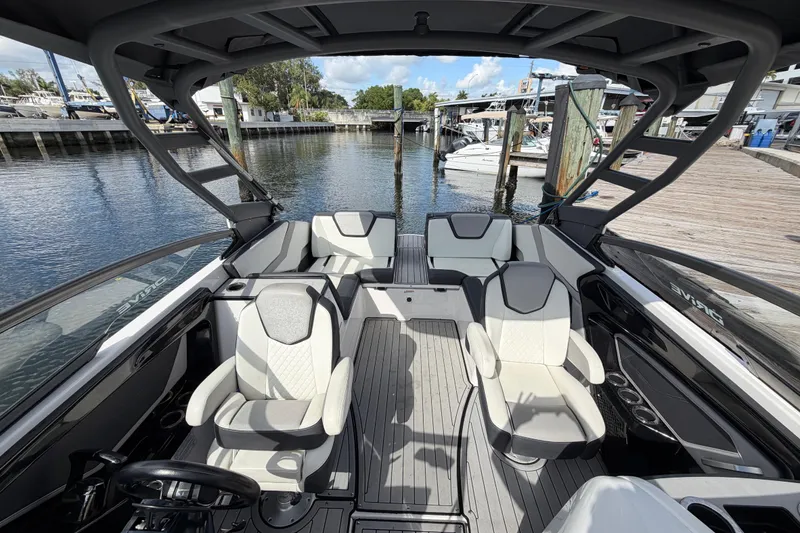 Slide: The Image of 2022 Yamaha Boats 252SD interior with sleek seating and modern design at a marina. - 5