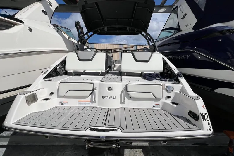 Slide: The Image of 2022 Yamaha Boats 252SD interior, sleek design, docked at marina. - 8