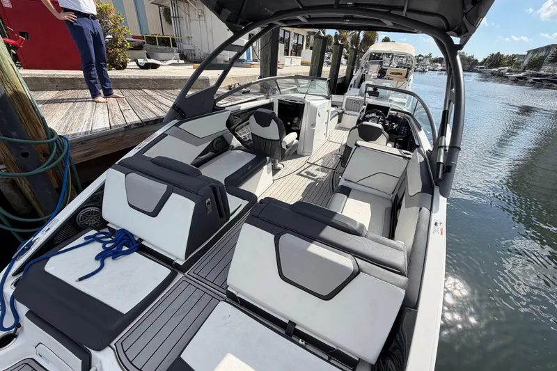 Slide: The Image of 2022 Yamaha Boats 252SD interior view at dock, showcasing seating and helm. - 9