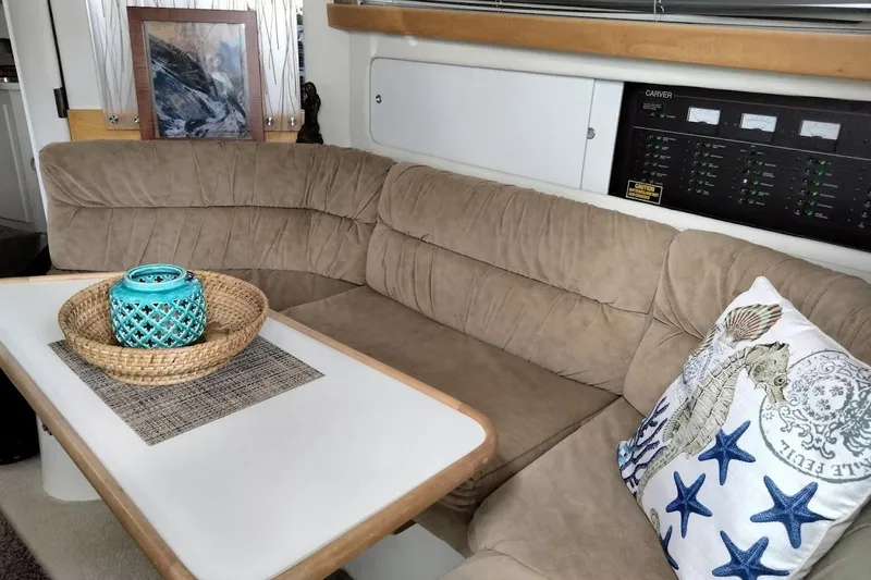 Slide: The Image of 1994 Carver 380 Santego interior with beige seating, decorative pillow, and wicker basket. - 13