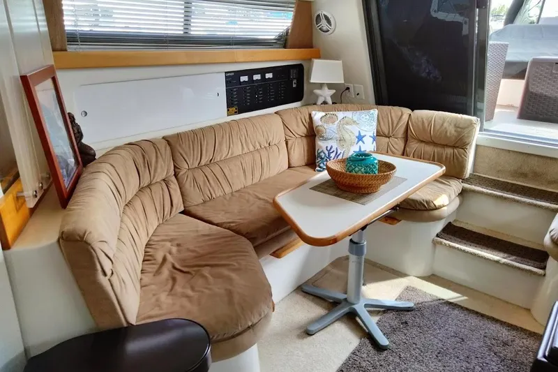 Slide: The Image of 1994 Carver 380 Santego interior with cozy seating, table, and nautical decor. - 16