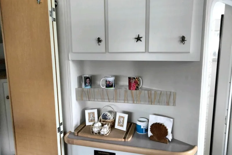 Slide: The Image of 1994 Carver 380 Santego interior with decorative shelf, mugs, and framed photos. - 19