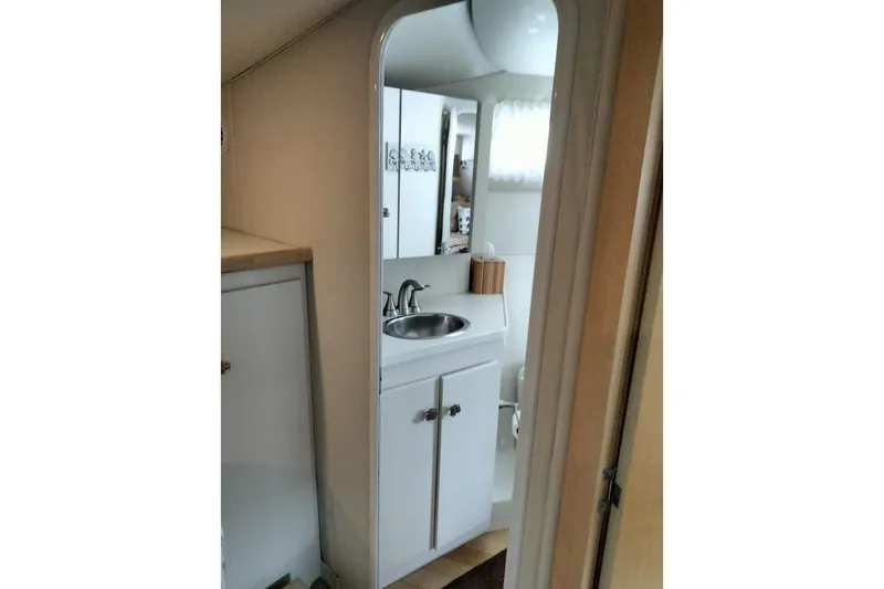 Slide: The Image of 1994 Carver 380 Santego yacht bathroom with sink, mirror, and storage cabinet. - 25