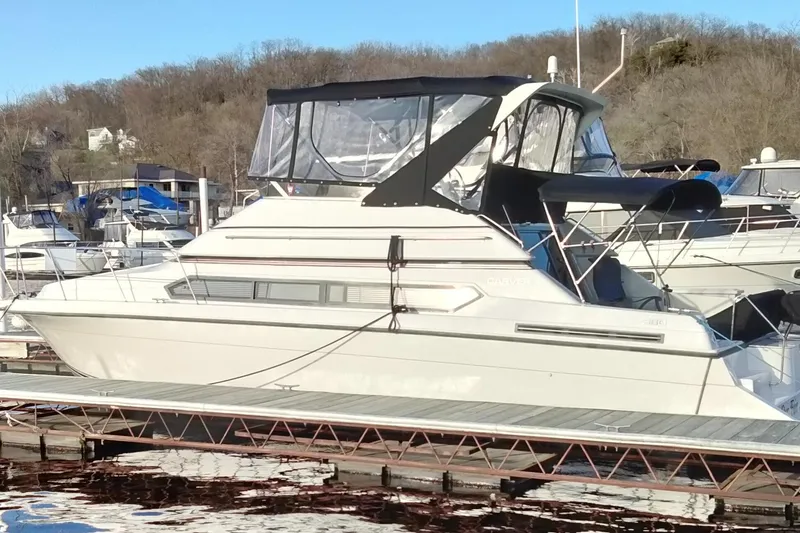 Slide: The Image of 1994 Carver 380 Santego yacht docked at marina, featuring sleek design and covered upper deck. - 4
