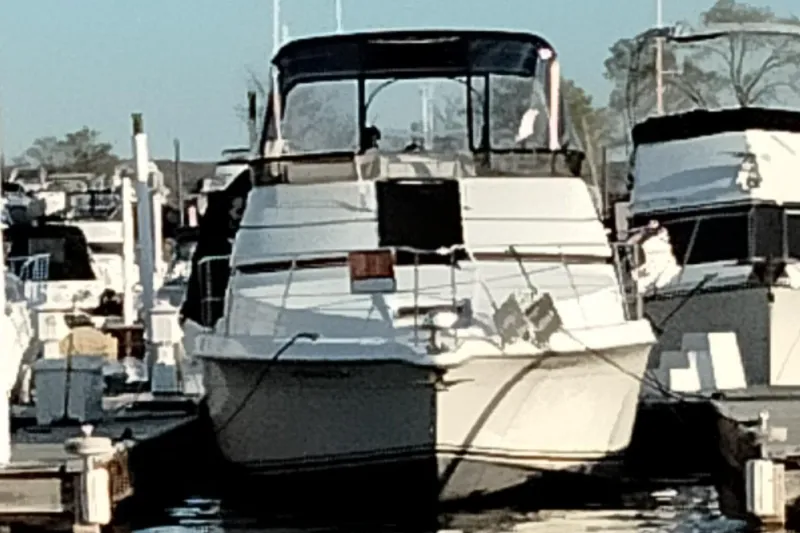 Slide: The Image of 1994 Carver 380 Santego yacht docked at a marina, surrounded by other boats. - 6