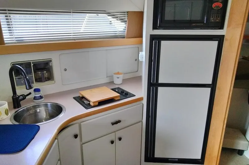 Slide: The Image of 1994 Carver 380 Santego yacht kitchen with sink, stove, and microwave. - 9