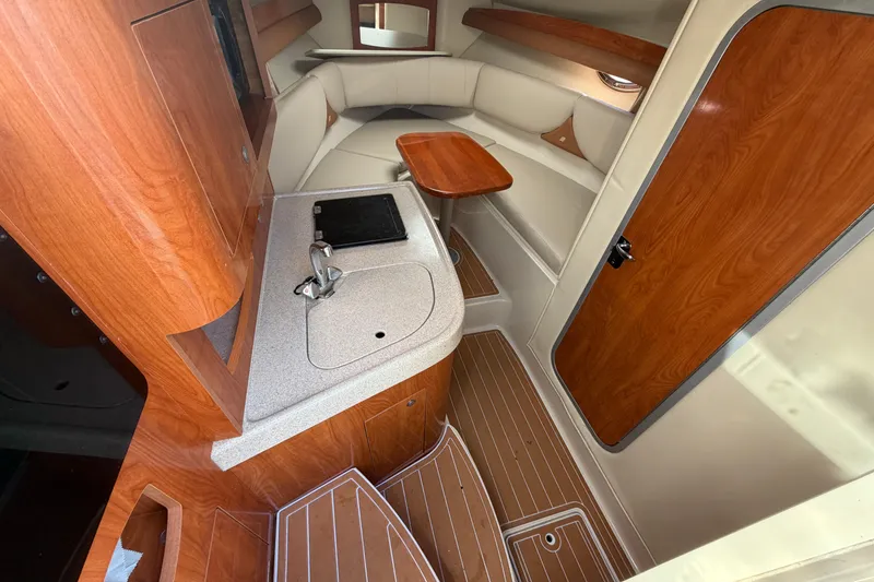 Slide: The Image of 2006 Four Winns 278 Vista cabin interior with wood finish and compact kitchenette. - 19