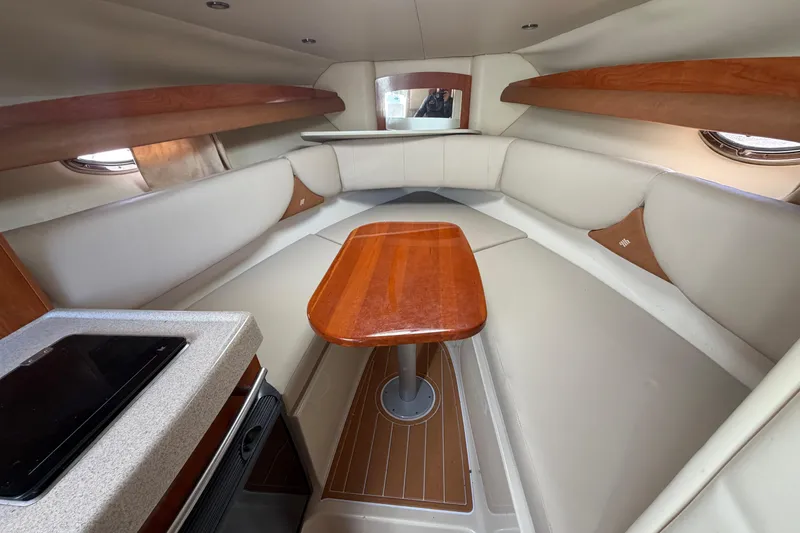 Slide: The Image of 2006 Four Winns 278 Vista cabin interior with wood accents and seating area. - 20