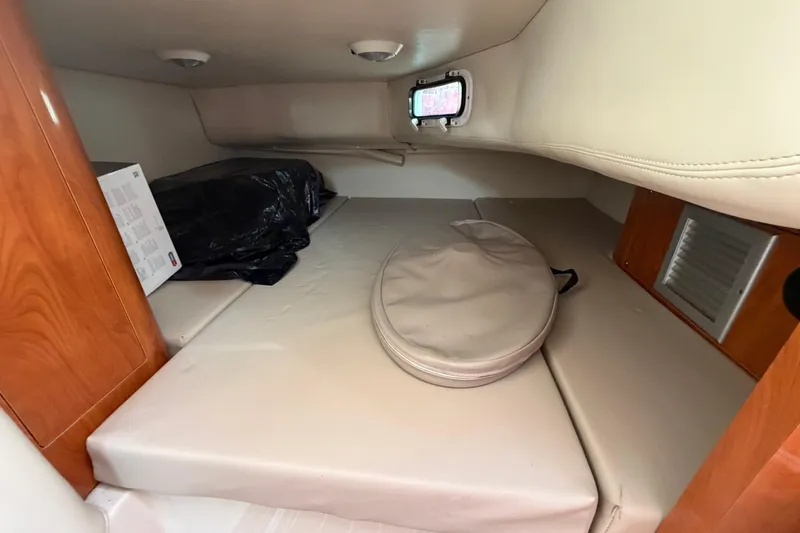 Slide: The Image of 2006 Four Winns 278 Vista cabin interior with beige cushions and wooden accents. - 22