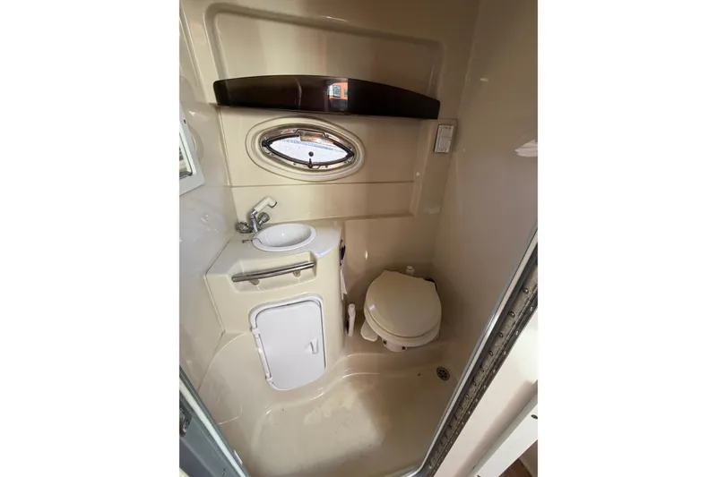 Slide: The Image of 2006 Four Winns 278 Vista boat bathroom with sink, toilet, and porthole window. - 25