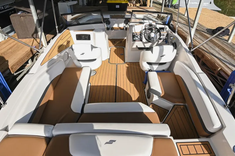 Slide: The Image of 2023 Starcraft SVX 230 IO boat interior with tan and white seating, wooden flooring. - 13