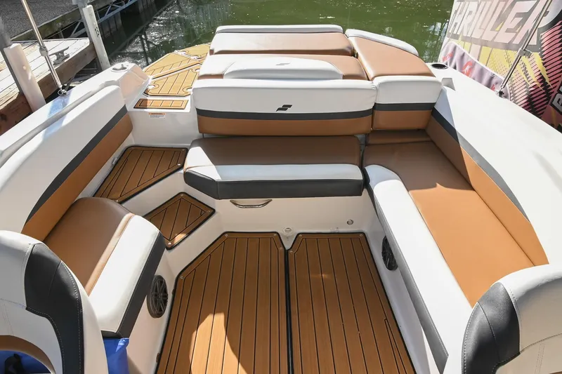 Slide: The Image of 2023 Starcraft SVX 230 IO boat interior with tan and white seating, wood-style flooring. - 14