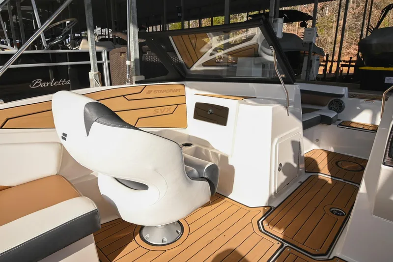 Slide: The Image of 2023 Starcraft SVX 230 IO boat interior with modern seating and wood accents. - 19