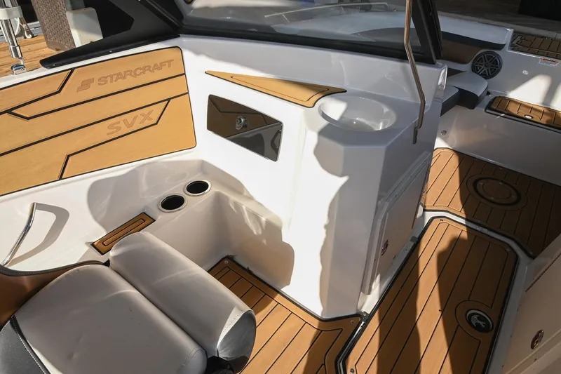Slide: The Image of 2023 Starcraft SVX 230 IO boat interior with wood accents and seating. - 21