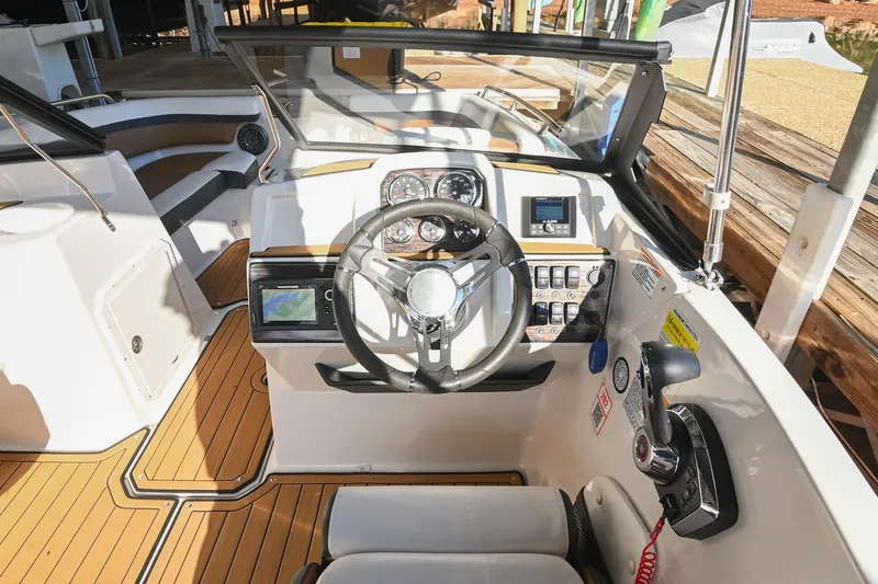 Slide: The Image of 2023 Starcraft SVX 230 IO boat cockpit with modern steering and control panel. - 24