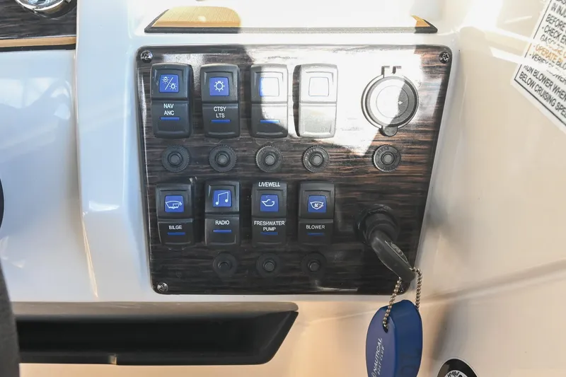 Slide: The Image of Control panel of 2023 Starcraft SVX 230 IO boat with labeled switches and key. - 28