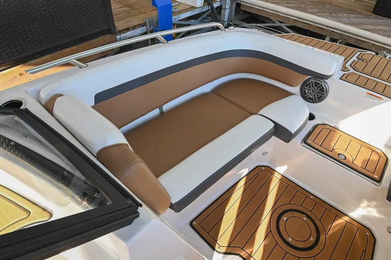 Slide: The Image of 2023 Starcraft SVX 230 IO boat interior with brown and white seating, wood-patterned flooring. - 34