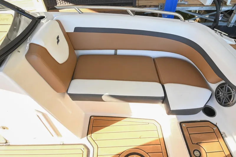 Slide: The Image of 2023 Starcraft SVX 230 IO boat interior with brown and white cushioned seating. - 35