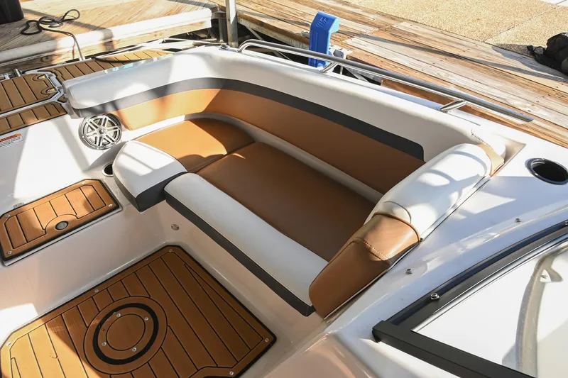 Slide: The Image of 2023 Starcraft SVX 230 IO boat interior with brown and white seating, wood-style flooring. - 37