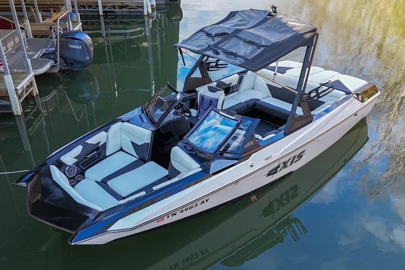 Slide: The Image of 2022 Axis A22 boat with sleek design, docked on calm water. - 1