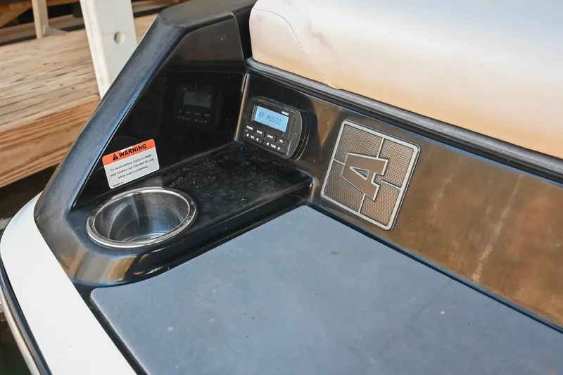 Slide: The Image of 2022 Axis A22 boat interior with control panel, cup holder, and warning label. - 12