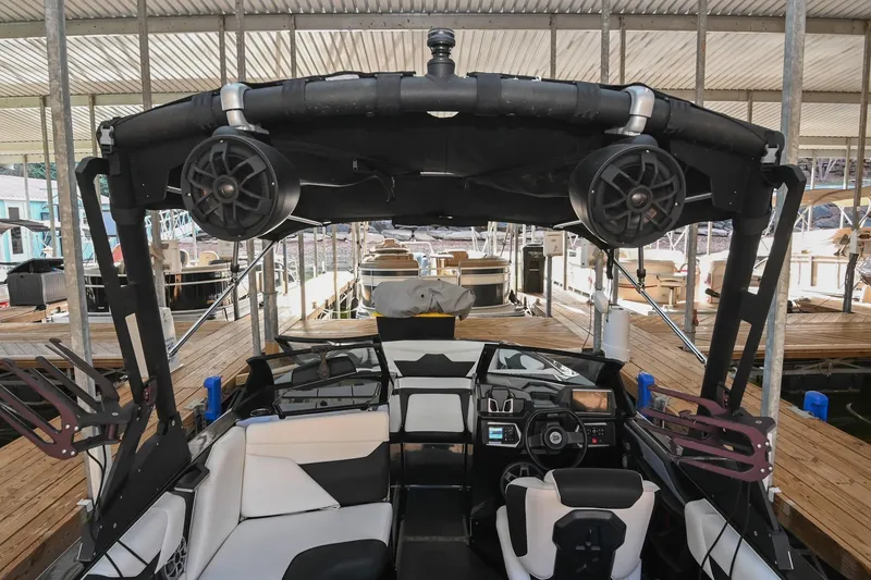 Slide: The Image of 2022 Axis A22 boat interior with speakers and seating at a dock. - 14
