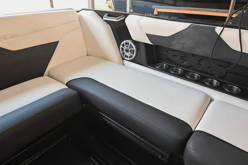 Slide: The Image of 2022 Axis A22 boat interior with black and white seating, cup holders, and speaker. - 19