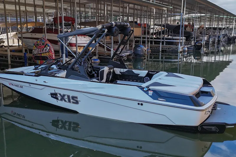 Slide: The Image of 2022 Axis A22 boat docked in marina, featuring sleek design and modern amenities. - 2
