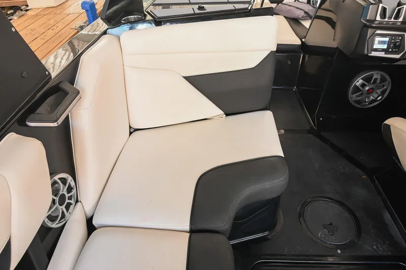 Slide: The Image of 2022 Axis A22 boat interior with beige and black seating, speaker, and control panel. - 23