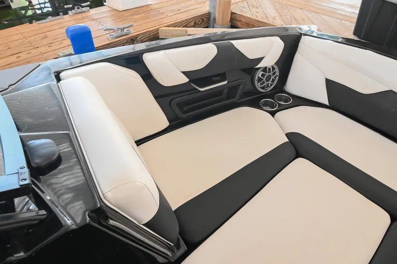 Slide: The Image of 2022 Axis A22 boat interior with black and white seating, cup holders, and speaker. - 33