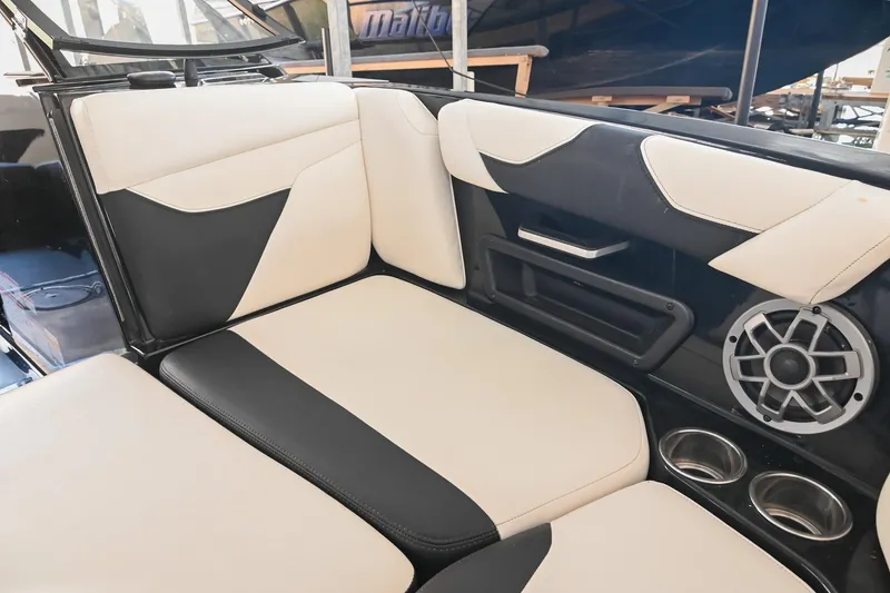 Slide: The Image of 2022 Axis A22 boat interior with black and white seating, speaker, and cup holders. - 34