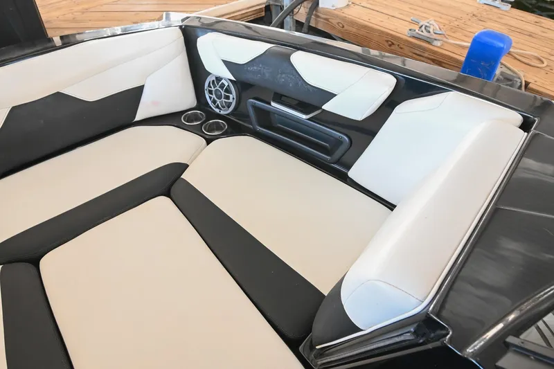 Slide: The Image of 2022 Axis A22 boat interior with beige and black seating, cup holders, and speaker. - 35