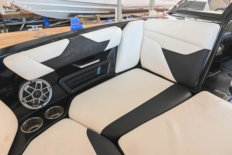 Slide: The Image of 2022 Axis A22 boat interior with black and white seating, speaker, and cup holders. - 36