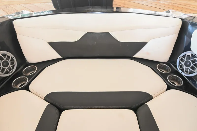 Slide: The Image of 2022 Axis A22 boat interior with beige and black seating, cup holders, and speakers. - 38
